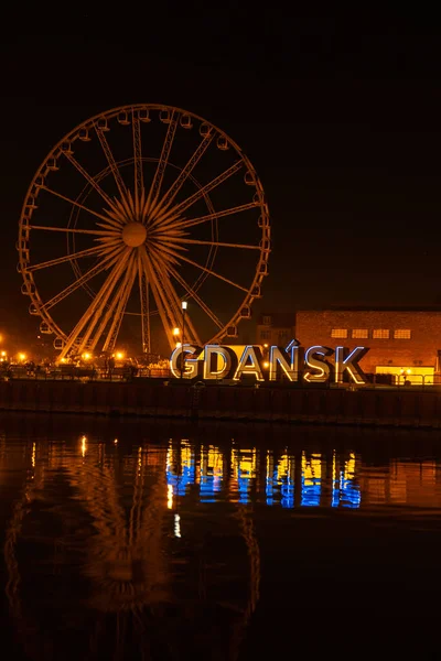 2022 년 3 월 폴란드 그단스크 (Gdansk Poland) 에서 밤에 구 도시 그단스크 (Gdansk) 의 페리스 휠 (Ferris wheel) 이 그단스크 (Gdansk Poland Europe) 에서 우크라이나 국기의 파란색 과 노란색을 반사한다. 우크라 이나를 지원하고 지원하다 — 스톡 사진