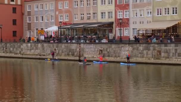 Gdansk Polonya Mart 2022 Sup sörfçüleri grubu ayağa kalkar, kadınlar eski şehir Gdansk Polonya 'da Motlawa nehri ve kanalında birlikte kürek çekerler. Turizm eğlencesi Aktif açık hava — Stok video