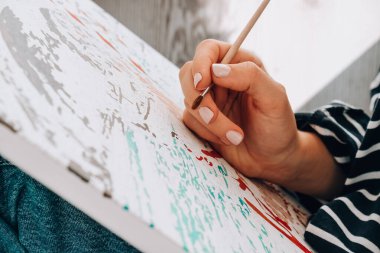 Tabloya numaralarla ve numaralandırılmış boya kavanozlarıyla resim yapmak. Kadın fırçayla tuvale numaralar çiziyor. Yaratıcı hobi. Yeni başlayanlar için resim yapmak. Evde kilitli kalmak için boş zaman aktivitesi, stres önleyici bir fikir. Meditasyon, rahatlama konsepti