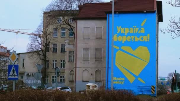Gdansk Polonia Marzo 2022 UCRANIA LUCHA contra el texto en GRAFFITI con gran corazón en colores de bandera ucraniana. Mural pintado en edificio casa Polonia Gdansk Europa Solidaridad y apoyo con Ucrania — Vídeos de Stock
