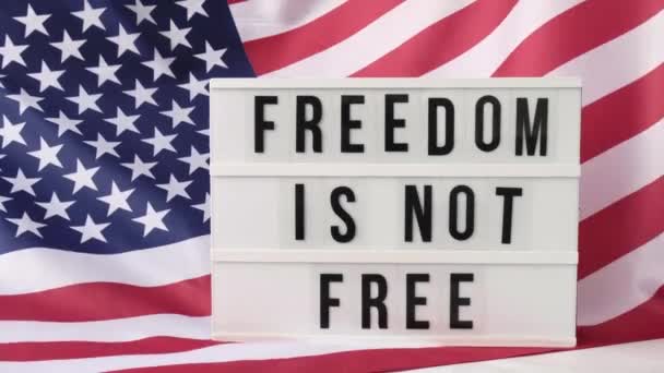 4kアメリカ国旗背景を振る。テキストのあるLightbox FREEDOMは米国の自由旗ではありません。7月4日独立記念日。アメリカ愛国心の祝日。宇佐誇り. — ストック動画