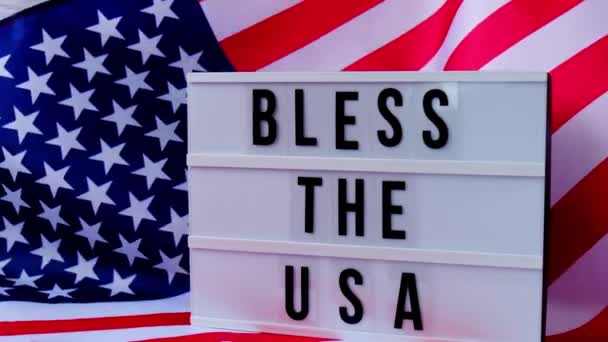 4k Waving American Flag Background. Lightbox with text BLESS THE USA Flag of the united states of America. July 4th Independence Day. USA patriotism national holiday. Usa proud. — 비디오