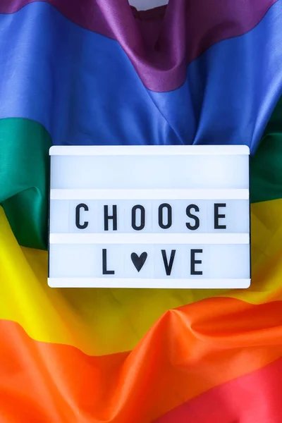 ライトボックスとテキストでレインボーフラグを選択愛。シルク素材で作られたレインボーlgbtqフラグ。LGBTQプライド月間のシンボル。平等な権利。平和と自由 — ストック写真