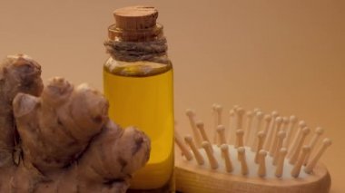 Cam şişe zencefil yağı, bej arka planda zencefil kökü. Sağlıklı alternatif yaşam. Saç bakımı için doğal kozmetik malzemeleri. Wellness Ev Yapımı Saç Maskesi Tedavisi
