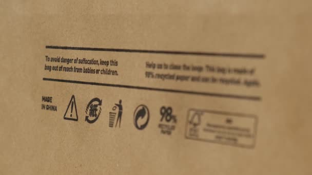 Переработка мешок Вид крупным плакатом и другой эко-этикетки на коричневый бумажный пакет, который является 100 перерабатываемых и многоразового использования spbd. Символ указывает на бумагу и картон. Концепция: экологическая безопасность — стоковое видео