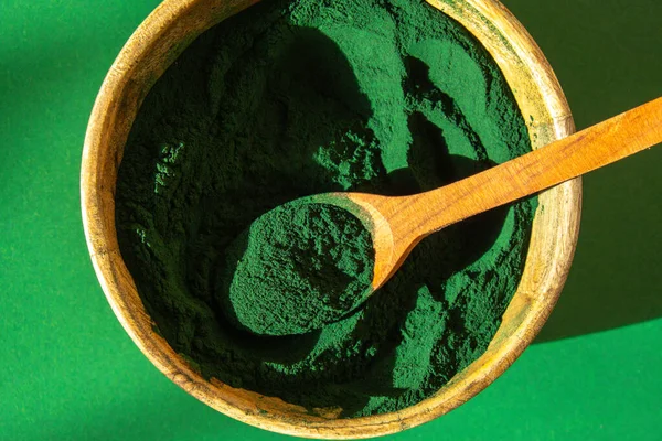 Mavi-yeşil yosun klorella ve bambu eko kasesinde spirulina tozu. Süper toz kaşıkta. Detox süper yiyecekler. Doğal yosun takviyesi
