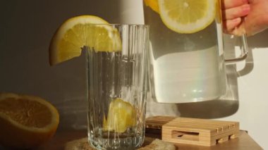 Yeniden kullanılabilir cam çubuklarla taze limon suyu ekleyin. Soğuk tonik, güneşli limon dilimleri, düşük atık yaşam tarzı Eko-Dost Canlısı Saman İçen Saman. 