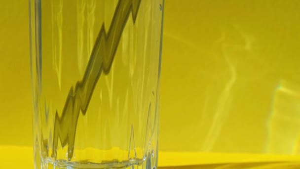 Pajitas de vidrio reutilizables en vidrio con agua sobre fondo amarillo Set de pajitas ecológicas para beber con cepillo de limpieza. Cero residuos, concepto libre de plástico — Vídeo de stock