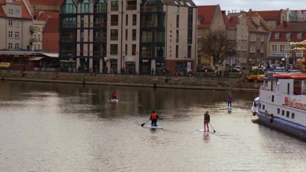 Gdansk Polonia Marzo 2022 Grupo de surfistas de sup se ponen de pie tabla de paddle, las mujeres se levantan remando juntos en la ciudad Motlawa río y canal en el casco antiguo de Gdansk Polonia. Atracción turística Activo al aire libre — Vídeos de Stock