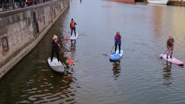 Gdansk Polônia março 2022 Grupo de surfistas sup stand up paddle board, as mulheres se levantam remando juntos na cidade Motlawa rio e canal na cidade velha Gdansk Polônia. Atração turística Ativo ao ar livre — Vídeo de Stock