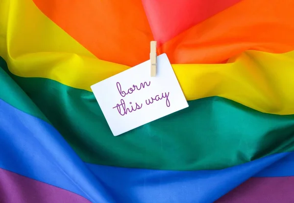 Tęczowa flaga z tekstem ZNAJDŹ TĄ WIĘCEJ wiadomości na papierze. Tęczowa flaga Igbtq wykonana z jedwabiu. Symbol miesiąca dumy LGBTQ. Równe prawa. — Zdjęcie stockowe