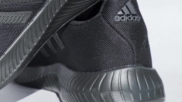 Kyjev Ukrajina - Říjen 2021 Black Adidas tenisky rotující na displeji. Nadnárodní společnost. Výstřely. Adidas rychlá běžecká obuv pro ženy - ilustrativní editorial — Stock video