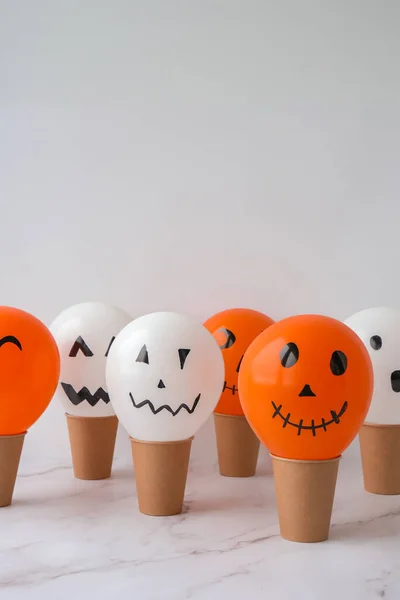 Painted Jacks face on balloons. Orange and white balls preparation diy for halloween party. Halloween home activities. Handmade toys Children craft