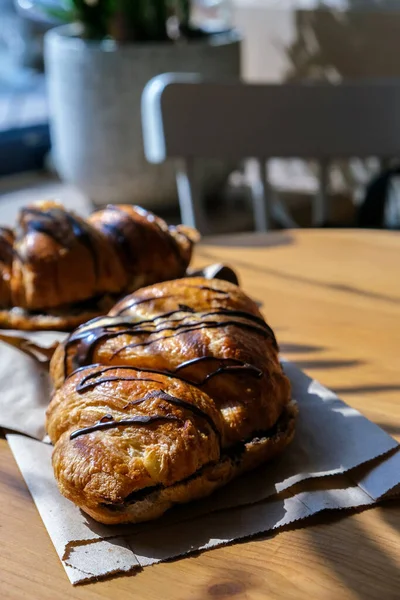 Friss Ízletes Croissant Csokis Vajjal Banánnal Gyűrött Papíron Reggeli Kávézóban — Stock Fotó