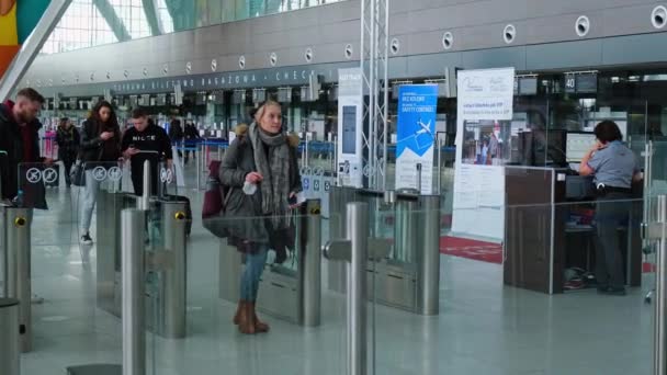 Danzig Polen - Mai 2022 Passagiere im Terminal des Danziger Flughafens warten auf ein Flugzeug. Menschen, die mit Rucksack und Koffer zu Flugreisenden laufen. Touristen am internationalen Flughafen — Stockvideo