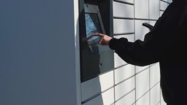 Alışveriş dolabından paket toplayan tanınmamış bir kadın. Cep telefonunda QR Kodu Barkod Okuyucu Modern Taşımacılık ve Temassız Taşıma Konseptine sahip self servis hücresi