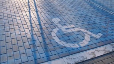 Engelli park yeri. Engelli park yerleri için ayrılmış park levhası koyu asfalta boyanmış mavi park levhası tekerlekli sandalye işaretli bir park yerinde engelli işareti 