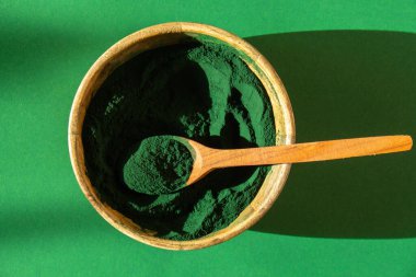 Mavi-yeşil klorella ve bambu eko kasesinde spirulina tozu, vegan, vejetaryen ya da bitki temelli diyet multivitamin B12, kaşıkta süper toz. Gıda takviye kaynağı