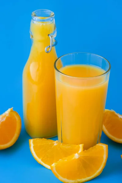 Стеклянная Бутылка Свежего Апельсинового Сока Нарезанными Фруктами Синем Фоне Фруктовый — стоковое фото