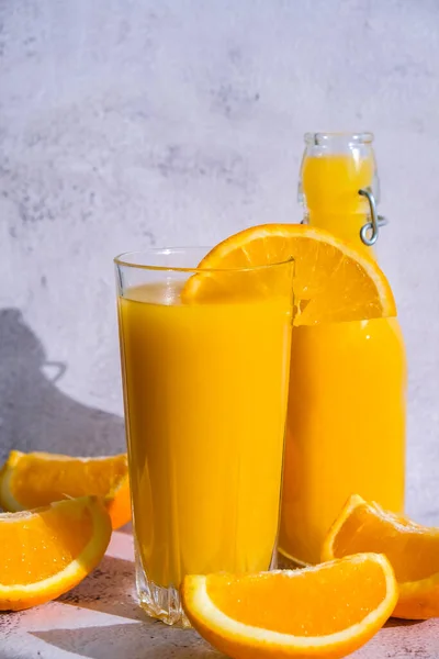 Szklana Butelka Świeżego Soku Pomarańczowego Plasterkami Owoców Betonowym Tle Sok — Zdjęcie stockowe