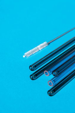 Renkli arka planda yeniden kullanılabilir cam pipetler temizlik fırçası ile çevre dostu içme saman seti yeniden kullanılabilir konforlu yuvarlak uçlu pipet içme. Sıfır atık, plastiksiz konsept. Sürdürülebilir