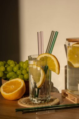 Glass of water with fresh lemon juice with Reusable glass Straws Detox cold tonic water with sunny lemon slices Low-waste lifestyle Eco-Friendly Drinking Straw Set with cleaning brush. Zero waste