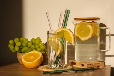Glass of water with fresh lemon juice with Reusable glass Straws Detox cold tonic water with sunny lemon slices Low-waste lifestyle Eco-Friendly Drinking Straw Set with cleaning brush. Zero waste