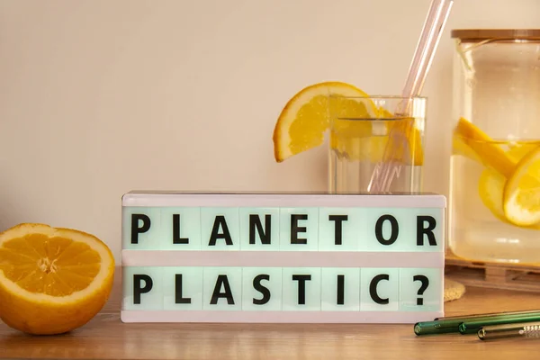 Lightbox with text PLASTIC OR PLANET Glass of water with fresh lemon juice with Reusable glass Straws Detox cold tonic water with sunny lemon slices Low-waste lifestyle Eco-Friendly Drinking Straw Set