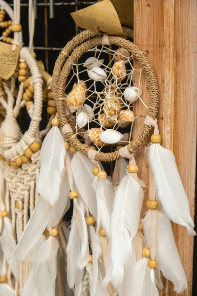 The Dream catcher Dream catcher with feathers threads and beads rope hanging. Dreamcatcher handmade. Souvenir gift shop. Hand made. Background for website design. Photo on the topic hygge, fika and