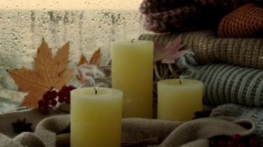 Şükran Günü ve Hello Fall, sonbahar tatillerini pencerenin kenarındaki evde kutluyoruz Hygge atmosferinde sonbahar yaprakları, baharatlar ve sıcak sarı ışıklarda örülmüş sıcak bir kazak üzerine üflenmiş mum. Seçici