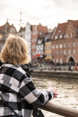 Gdansk 'ın eski kasabasında tanınmayan turist gezgini. Moltawa Nehir Kenti 'ndeki Granary Adası yansımasına bakan bir kadın. Alacakaranlıkta antik vinç. Gdansk Polonya 'ya Seyahat Hedefini Ziyaret Et