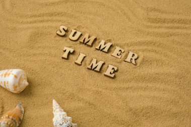 Yazılı Time deniz kabukları, çakıl taşları, kumsal zemininde maket. Boşluk, üst görünüm, durgun hayat, düzlük. Deniz seyahati konsepti turizm ve tatil beldeleri. Yaz tatili