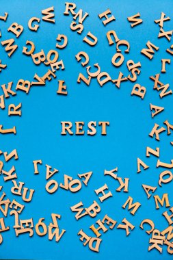 Kelime geri kalanı parlak mavi arkaplandaki ahşap harflerden yapılmış. Motivasyon Sözcükleri Kavramı. İlham verici bir ifade