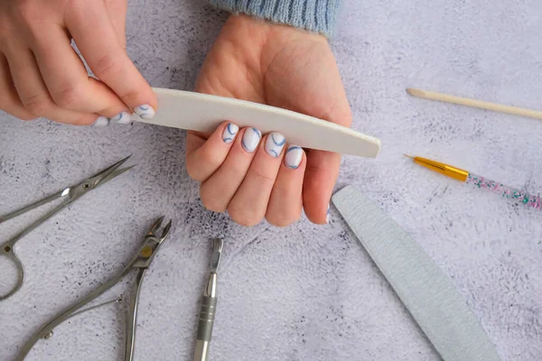 Professional stylish trendy blue Hardware Manicure. Procedure for the preparation of nails. Cuticle Pusher Remover. Nail file scissors Top view flat lay. Do manicure by yourself staying at home. Self care. Spa, beautician advertisement.