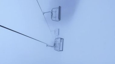 POV Boş Kayak Kaldırma Dağlık Kış Ormanı ve kışın Kayak Tatil Köyü 'nde sandalye kaldırma. Dikey görüntüler kar yağışlı hava tatili kış sporu ve açık hava turizm kayağı