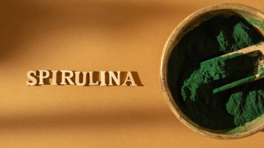 Bambu eko kabında mavi-yeşil alg spirulina tozu, SPIRULINA yazılı, vegan, vejetaryen ya da bitki bazlı diyet multivitaminler B12, kaşıkta süper toz. Gıda takviyesi