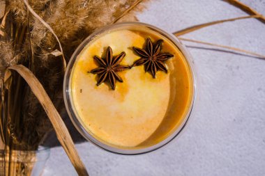 Balkabaklı, baharatlı latte. Anason yıldızları. Baharatlı balkabağı aromalı sonbahar kahvesi mevsimlik sıcak içecek. Cadılar Bayramı ve Şükran Günü için sonbahar içkileri. Vejetaryen sağlıklı diyet yemekleri