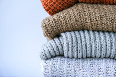 Stack of cozy knitted warm sweater. Sweaters in retro Style. Orange and blue colors. Cozy hygge concept Copy space Autumn winter season