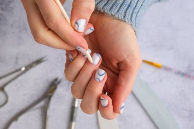 Profesyonel modaya uygun mavi hırdavat manikürü. Çivi hazırlama prosedürü. Tırnak içi temizleyicisi. Tırnak dosya makası Üst görünüm düz yatıyordu. Evde kalarak manikür yapsana. Kişisel bakım. Spa, güzellik reklamı..