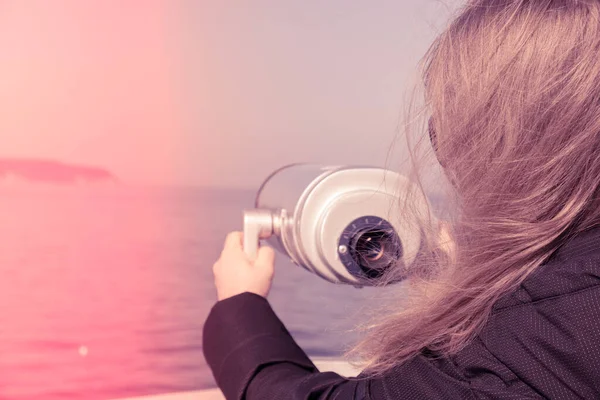 Tourist looking through coin operated binoculars. Binocular telescope on the observation deck for tourism. Sea background. Binoculars watching at horizon at ship deck. Discover new places Travel
