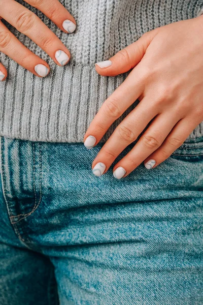 Manikürlü kadın elleri, zarif mavi tırnakları ve minimalist bir tasarımı var. Modern moda tasarım manikürü. Jel tırnaklar. Cilt bakımı. Sağlıklı Güzellik Tedavisi. Tırnak bakımı. Moda renkleri. Güzellik reklamı