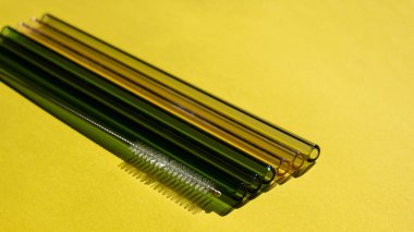 Reusable glass Straws on colorful background Eco-Friendly Drinking Straw Set with cleaning brush Reusable Comfortable Rounded tip Drinking Straw. Zero waste, plastic free concept. Sustainable