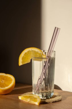 Glass of water with fresh lemon juice with Reusable glass Straws Detox cold tonic water with sunny lemon slices Low-waste lifestyle Eco-Friendly Drinking Straw Set with cleaning brush. Zero waste