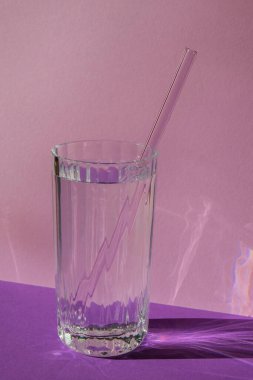 Mor menekşe arka planda suyu olan yeniden kullanılabilir cam pipetler temizlik fırçasıyla birlikte çevre dostu saman içme seti. Sıfır atık, plastiksiz konsept. Sürdürülebilir yaşam tarzı. Serbest yaşam israfı