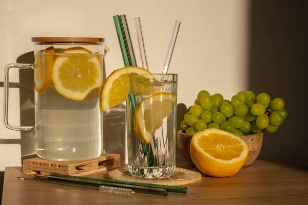 Glass of water with fresh lemon juice with Reusable glass Straws Detox cold tonic water with sunny lemon slices Low-waste lifestyle Eco-Friendly Drinking Straw Set with cleaning brush. Zero waste