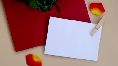 Bej arka planda kağıt zarfla süslenmiş bir buket kırmızı gül. Tatil için çiçek hediyesi. Teklif ya da düğün hediyesi fikri. Bayram için selamlar Yavaş çekim