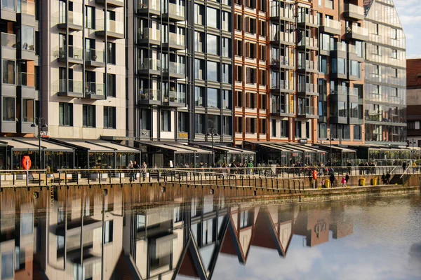 Old Town 'daki Motlawa Nehri üzerindeki modern binalar. Soyut yapı. Motlawa Nehri 'nde yaratıcı fotoğraf turizmi. Granary Adası cam pencerelerinde yansımalı yeni apartmanlar mimarisi