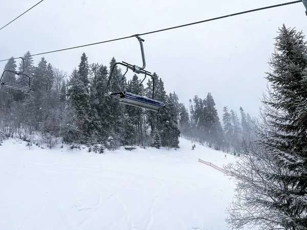 Ski Lift snowy mountain winter forest with chair lift At The Ski Resort in winter. Snowy weather Ski holidays Winter sport and outdoor activities Outdoor tourism skiing snowboarding