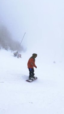 Plai Ukrayna - Şubat 2022 Dikey Kayak 4K görüntüleri, kayak tatilinde kayak pistinde uzun virajlarda usta snowboardcu. Kayak yapan kadın yokuş aşağı gidiyor