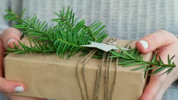 女人送贺岁礼物盒 用手工纸包好 再用冷杉枝条装饰 假期和礼物的概念 手工制造环保环保环保环保圣诞礼物零浪费 — 图库视频影像